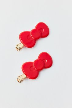 two red heart shaped clippers with gold clips on each side, one is attached to the other