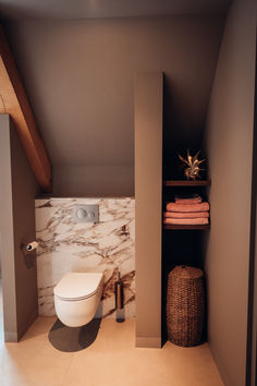 there is a toilet in the corner of this bathroom with marble walls and flooring