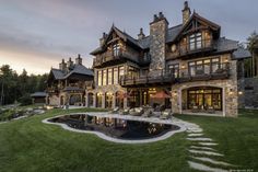 a large house with a pool in front of it and lots of windows on the side