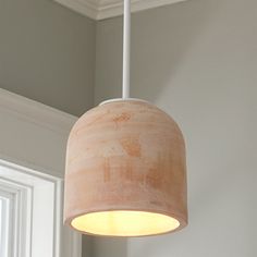 a light fixture hanging from the ceiling in a room with gray walls and white trim