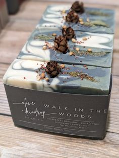 three bars of soap with pine cones on them sitting on a wooden table next to each other