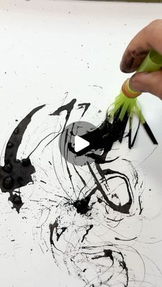 someone is drawing with black and green ink