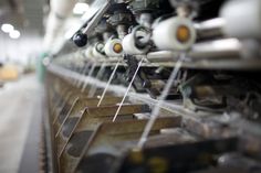 an assembly line with lots of machines in the background and one machine is spinning on it's side