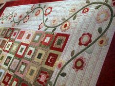 a red and white quilt with flowers on it