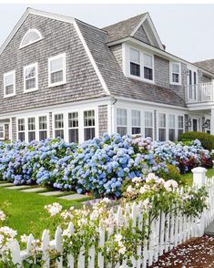 an instagram page with a house and flowers in the foreground, on which is also a white picket fence