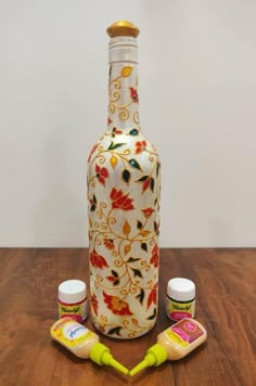 a bottle and two jars sitting on top of a wooden table