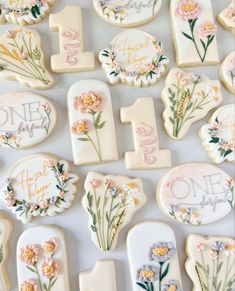 decorated cookies are arranged in the shape of numbers and flowers on a white tablecloth