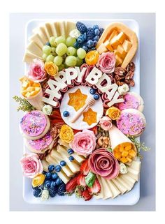 a happy birthday card made out of food on a plate with grapes, strawberries and other fruits