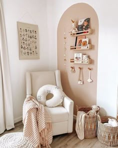 a white chair sitting in a living room next to a shelf filled with books and toys