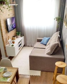 a living room filled with furniture and a flat screen tv sitting on top of a wooden table