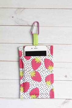 a cell phone is attached to a clipboard with polka dots and strawberries on it