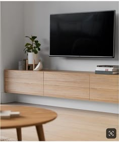 a flat screen tv sitting on top of a wooden entertainment center in a living room