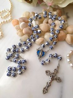 Handmade rosary made with 8mm ceramic blue & white floral beads a Virgin Mary center with blue background and a Fleur de Lis crucifix. Handmade Blue Rosary For Jewelry Making, Blue Cross Rosary As Gift, Blue Healing Rosary, Flower Rosary, Spiritual Blue Rosary With 108 Beads, Rosary Making, Knotted Rosary, Rosary Beads Necklace, Blue Rosary