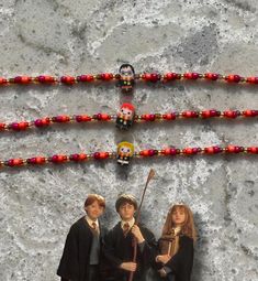 three harry potters are standing next to each other with beaded necklaces on them