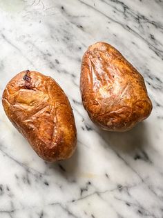 two loaves of bread sitting on top of a marble counter