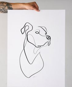 a person holding up a drawing of a dog