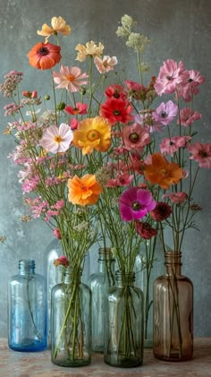 several vases filled with different colored flowers on a table