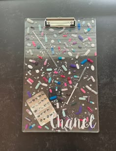 a clipboard with confetti on it and the word chanel written in cursive writing