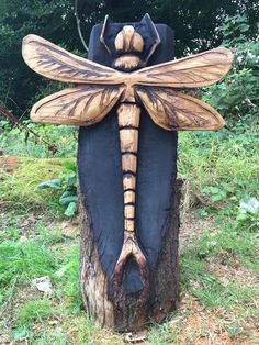 a wooden carving of a dragon sitting on top of a tree stump