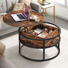 a coffee table with a laptop on it in the middle of a living room next to a couch