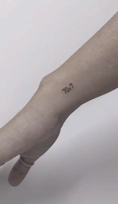 a person's arm with a small tattoo on the left side of their arm