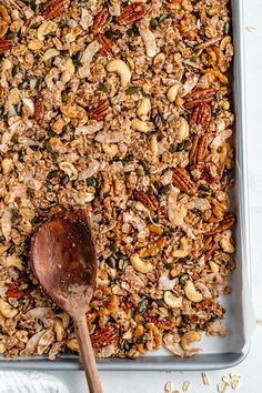 a pan filled with granola and a wooden spoon