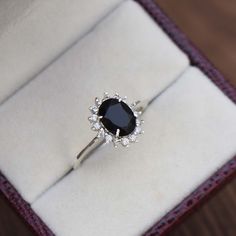 a black diamond ring sitting on top of a white box