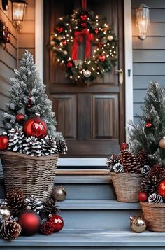 two baskets filled with christmas decorations sitting on the front steps next to a wreath and pine cones