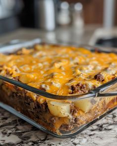 a casserole dish with meat, potatoes and cheese in it on a kitchen counter