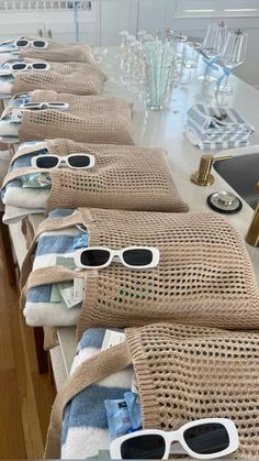 towels and sunglasses are lined up on the counter in front of glasses that are placed on top of each other