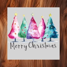 three watercolor christmas trees with the words merry christmas