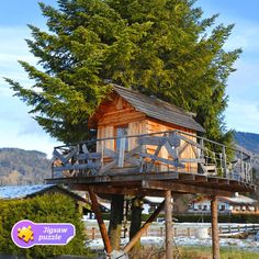 a wooden tree house sitting on top of a lush green field