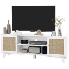 an entertainment center with a flat screen tv and wicker baskets on the bottom shelf