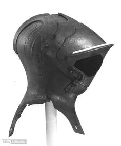 an old helmet is on top of a metal pole in front of a white background