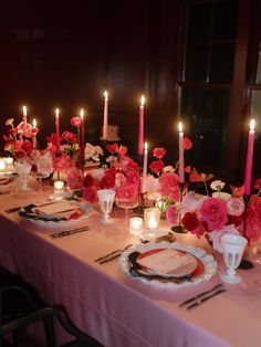 the table is set with pink flowers and candles for an elegant dinnereonal event