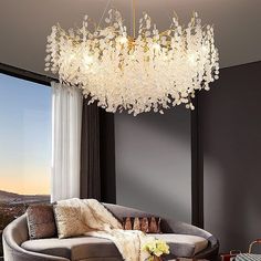 a living room filled with furniture and a chandelier hanging over the top of it