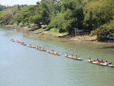 several canoes are lined up on the river bank as people ride in one boat