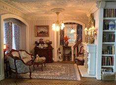 a living room filled with furniture and bookshelves next to a doorway that leads to another room