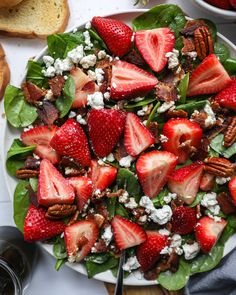 a salad with strawberries, pecans and goat cheese