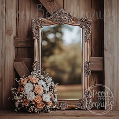 a mirror sitting on top of a wooden shelf next to a bouquet of flowers in front of it