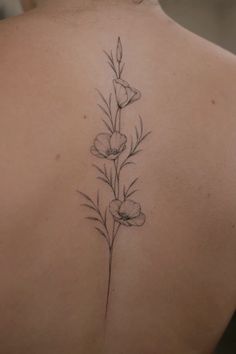 the back of a woman's shoulder with flowers and leaves on her left side