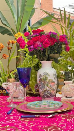 the table is set with pink and purple flowers