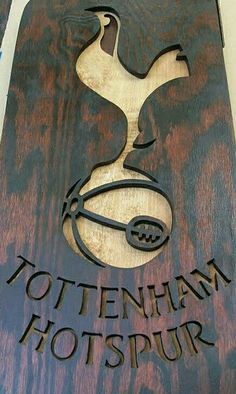 a wooden sign that says tottenham hotspur with a bird on it's head