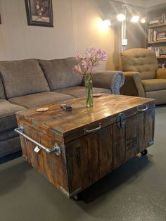 a living room filled with furniture and a wooden trunk on the floor next to a couch