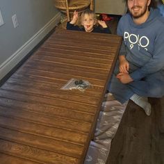 a man and child sitting at a wooden table