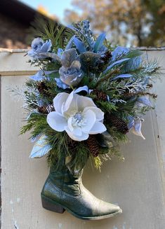 a green boot with flowers and pine cones