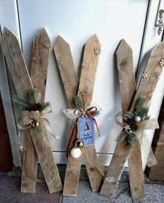 three wooden sticks with christmas decorations on them next to a door handle and two bells