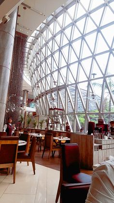 the inside of a restaurant with tables and chairs in front of a large glass window