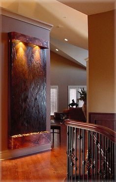 an entry way with a water feature on the wall and stairs leading up to it