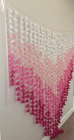 pink and white paper triangles hanging on the wall